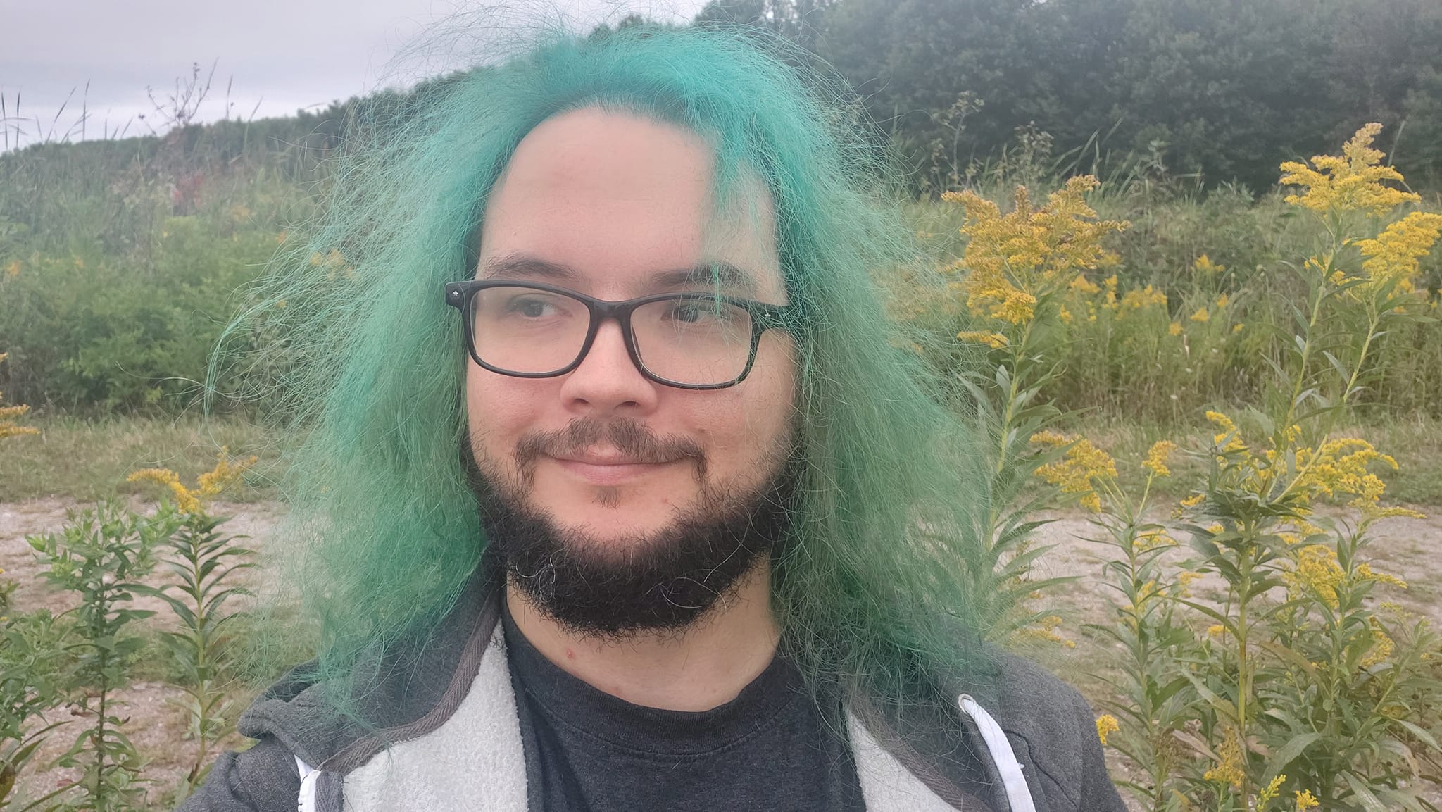 A man with green hair is visiting a freshwater marsh, photo 1